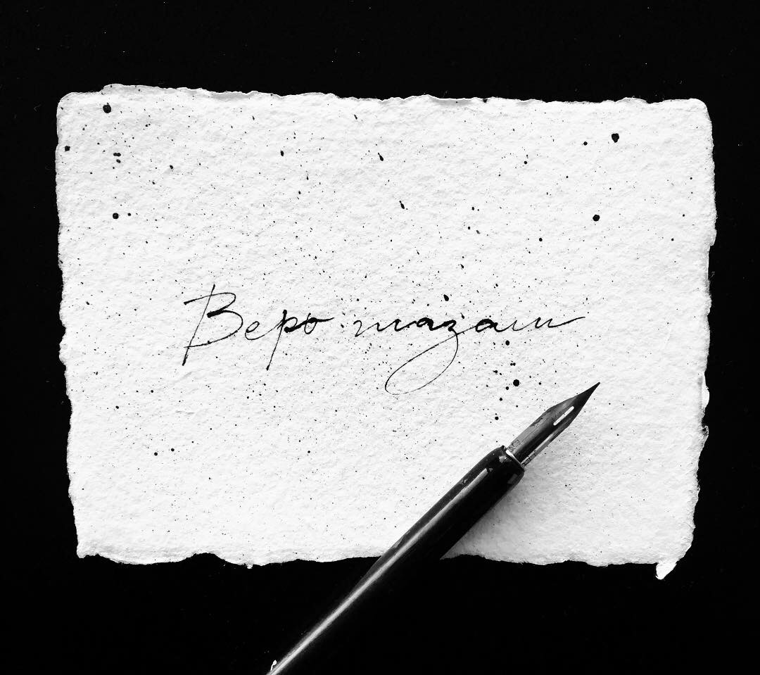 Calligraphy reading Bepo magazin on deckled handmade paper with a dip pen on a black background