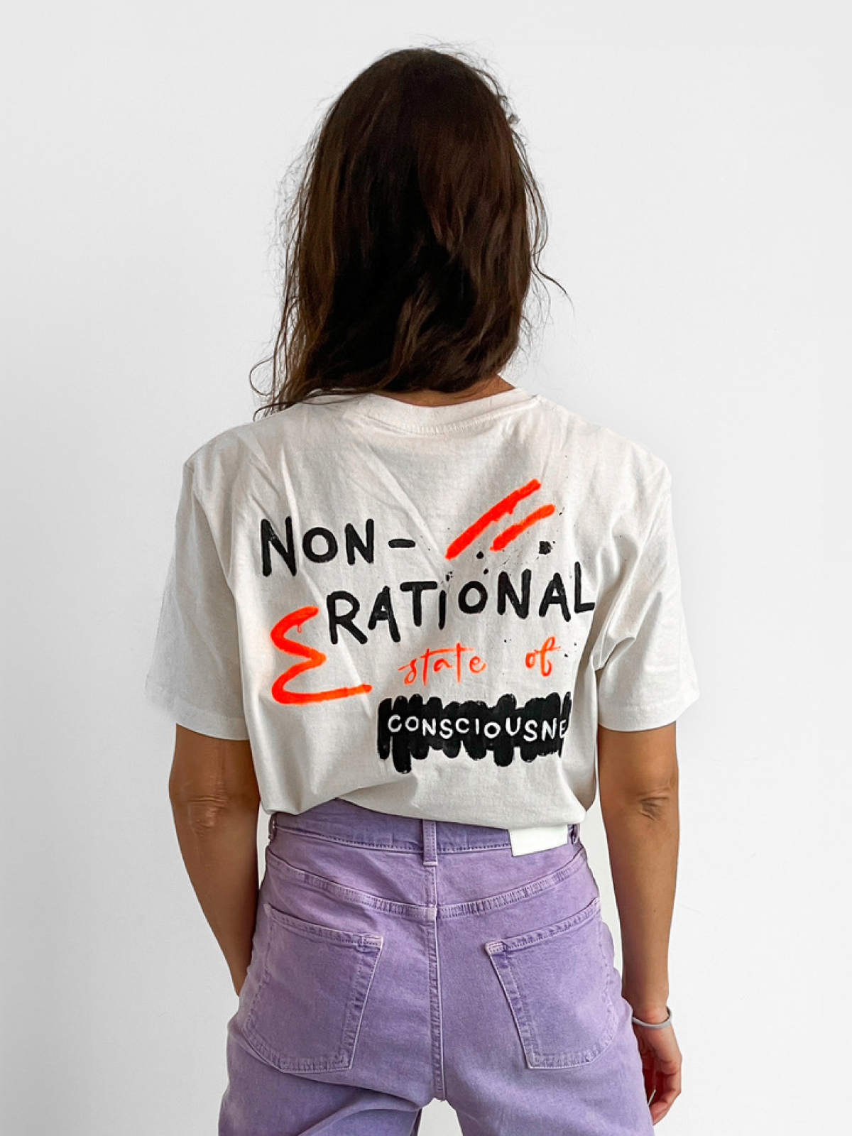 White t-shirt painted with NON-RATIONAL state of CONSCIOUSNESS hand-lettered graphic on the back