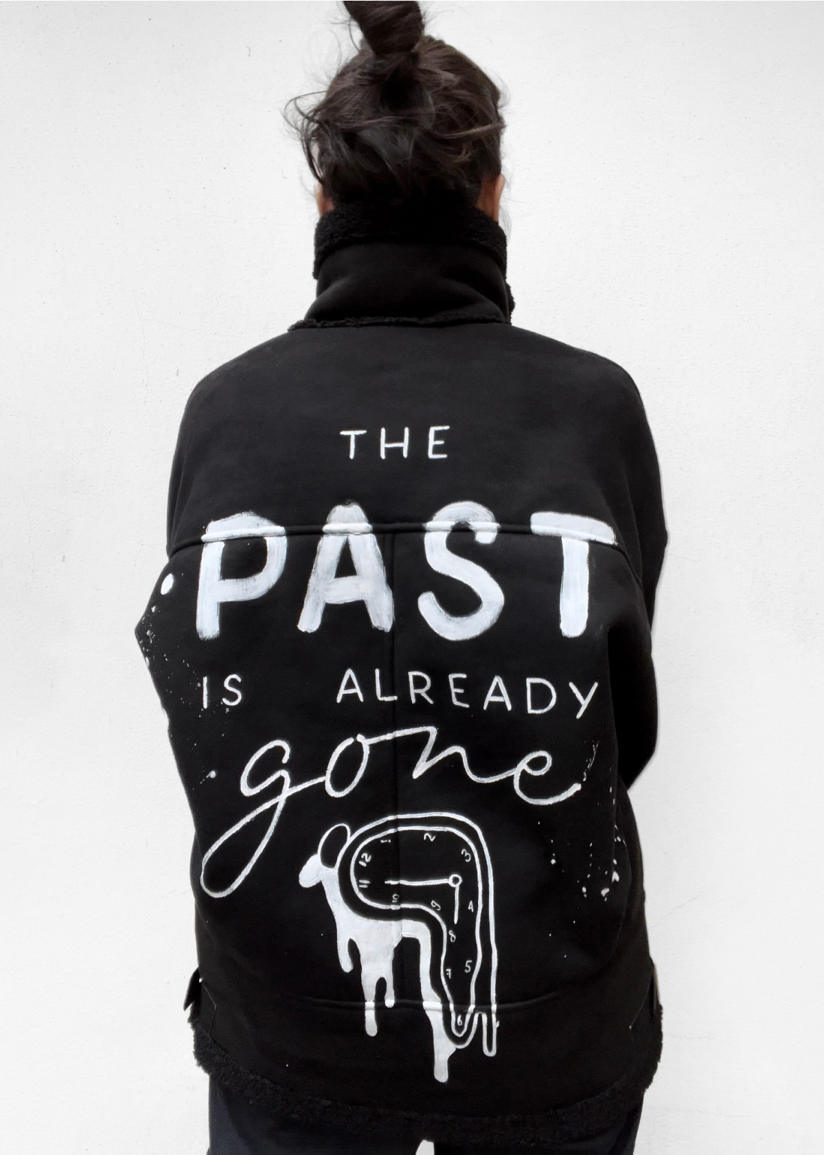 Black jacket with THE PAST IS ALREADY gone lettering and a melting Dalí-style clock painted on the back