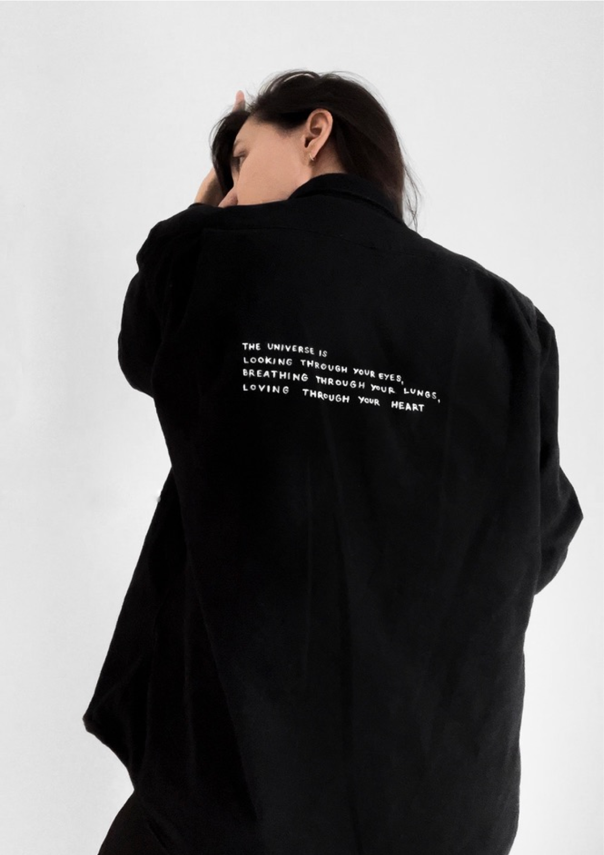 Black shirt with a white hand-lettered quote about the universe looking through your eyes, breathing through your lungs, and loving through your heart