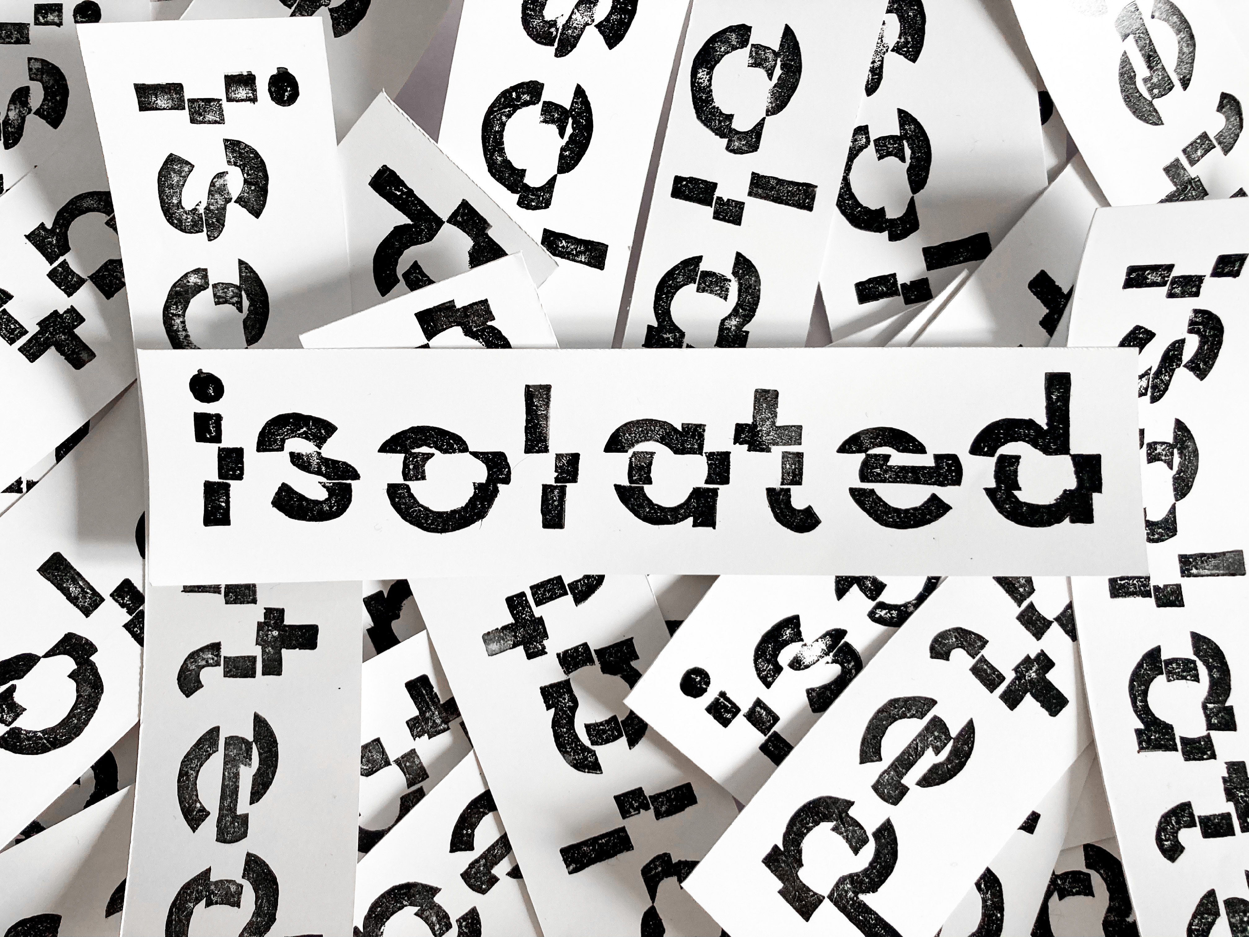 Pile of white stickers printed with the word isolated in a distressed black stencil font