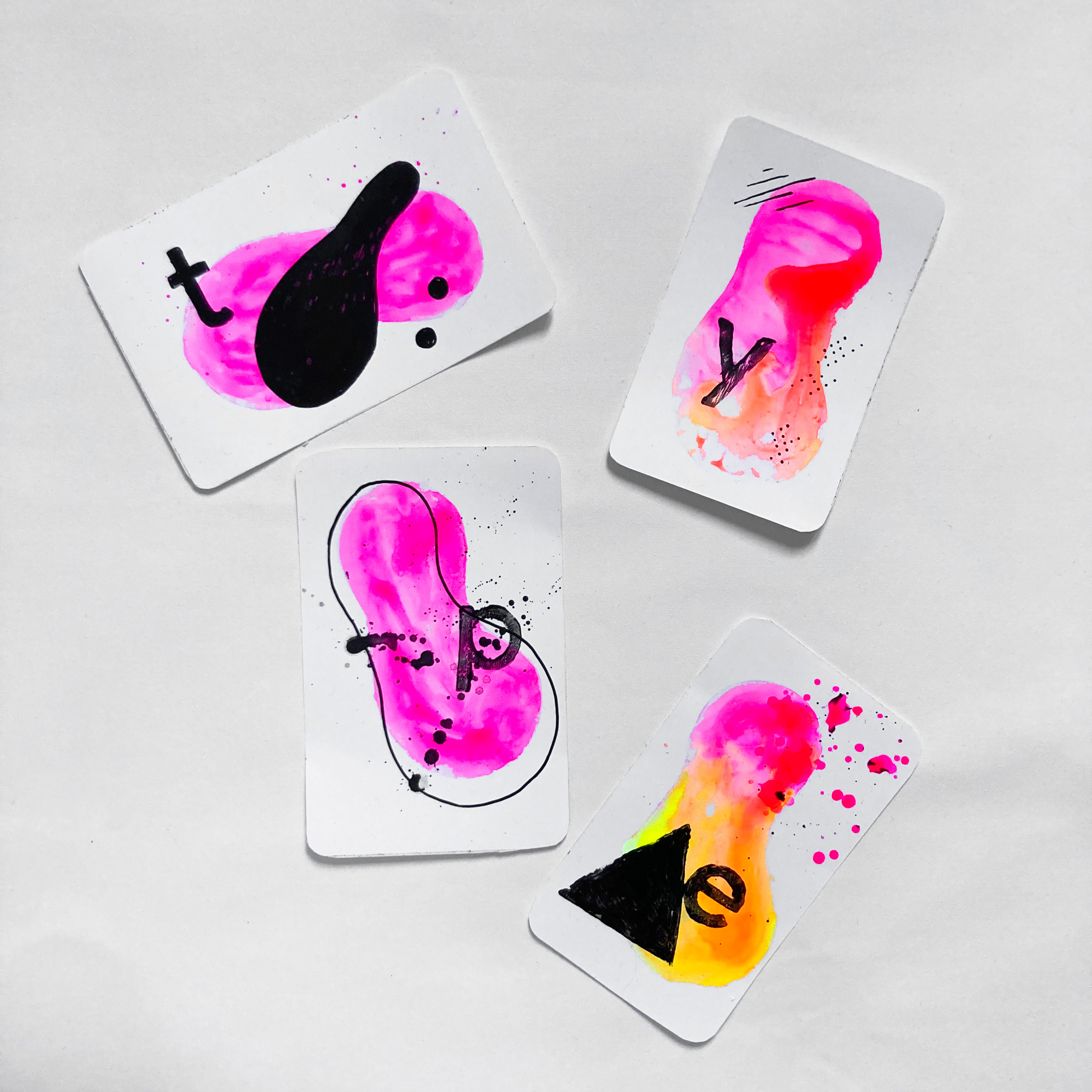 Four abstract sticker cards spelling type with pink, orange, and yellow ink blots and bold letterforms